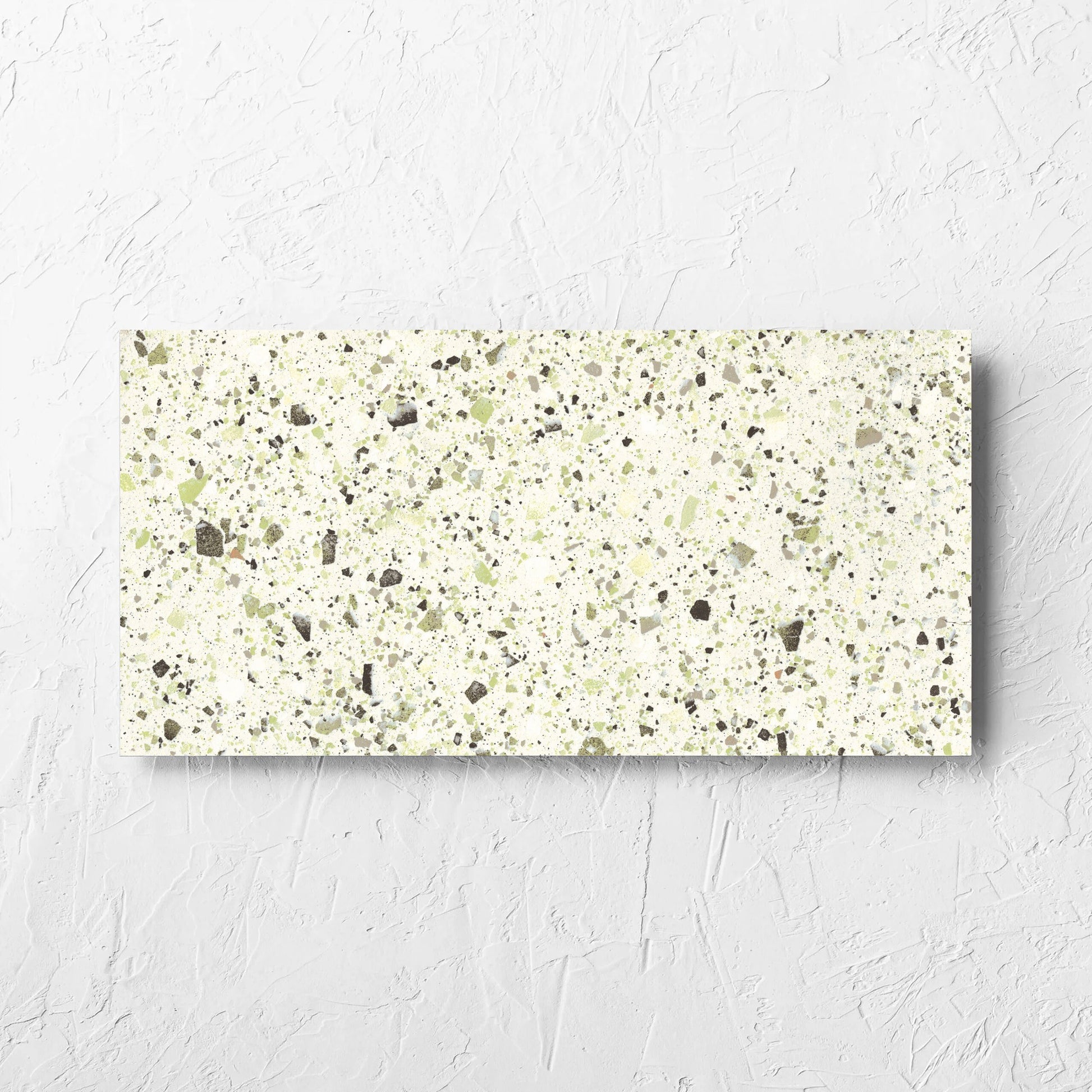 Venice Green 300x600mm Matt Terrazzo Tile laid flat on a white rendered wall, showing the green matt surface