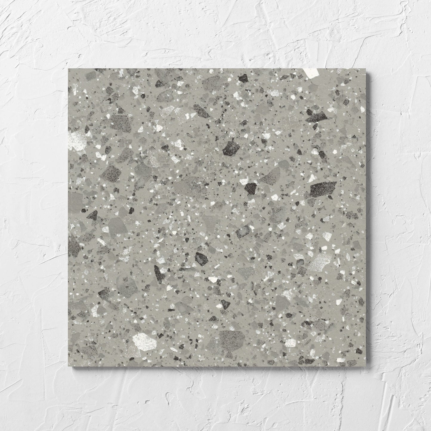 Venice Grey 300x300mm Matt Terrazzo Tile laid flat on a white rendered wall, showing the grey matt surface
