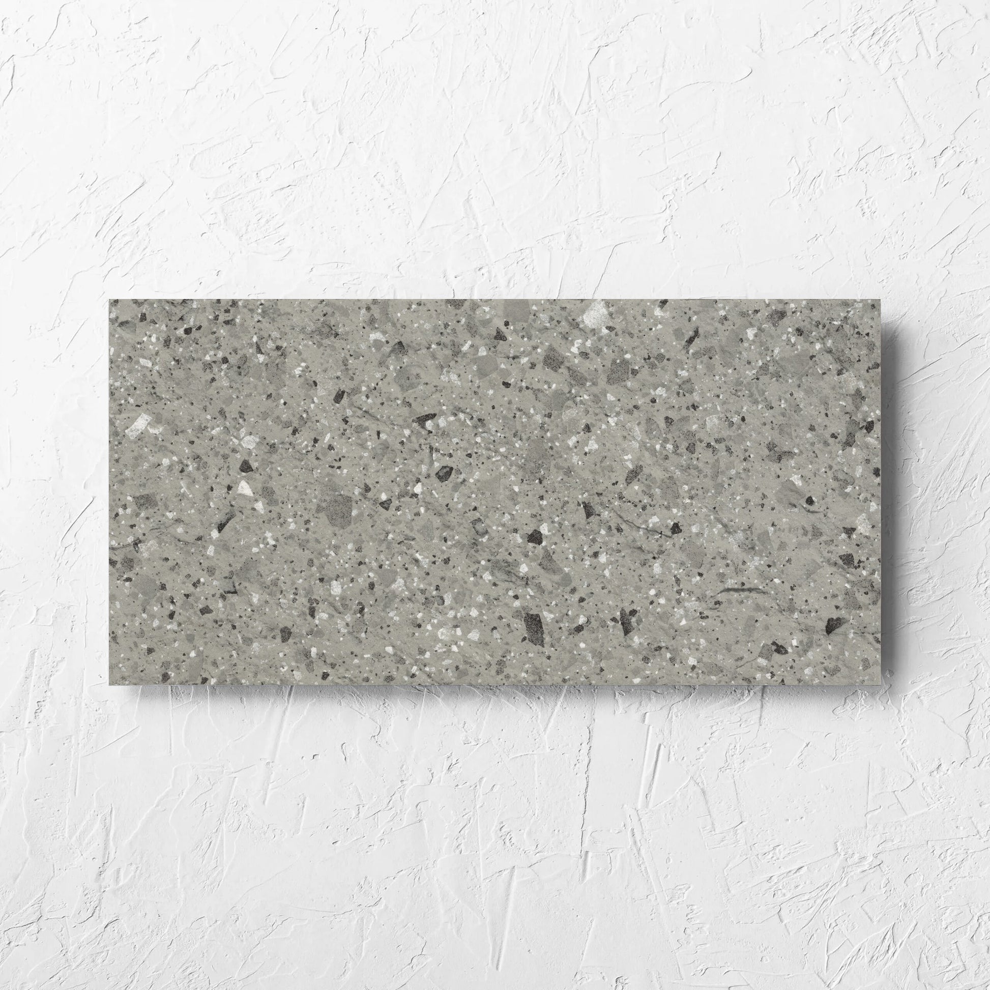 Venice Grey 300x600mm Matt Terrazzo External Tile laid flat on a white rendered wall, showing the grey matt surface