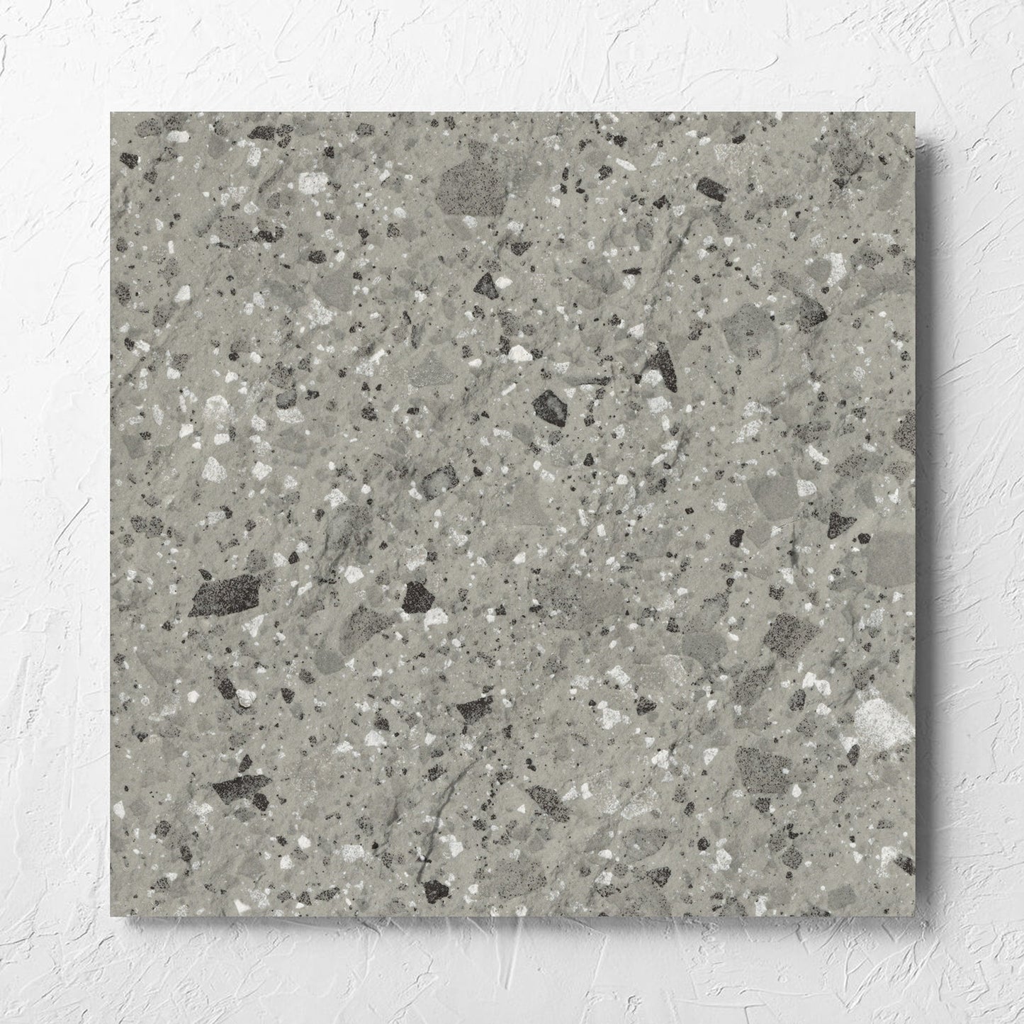 Venice Grey 600x600mm Matt Terrazzo External Tile laid flat on a white rendered wall, showing the grey matt surface