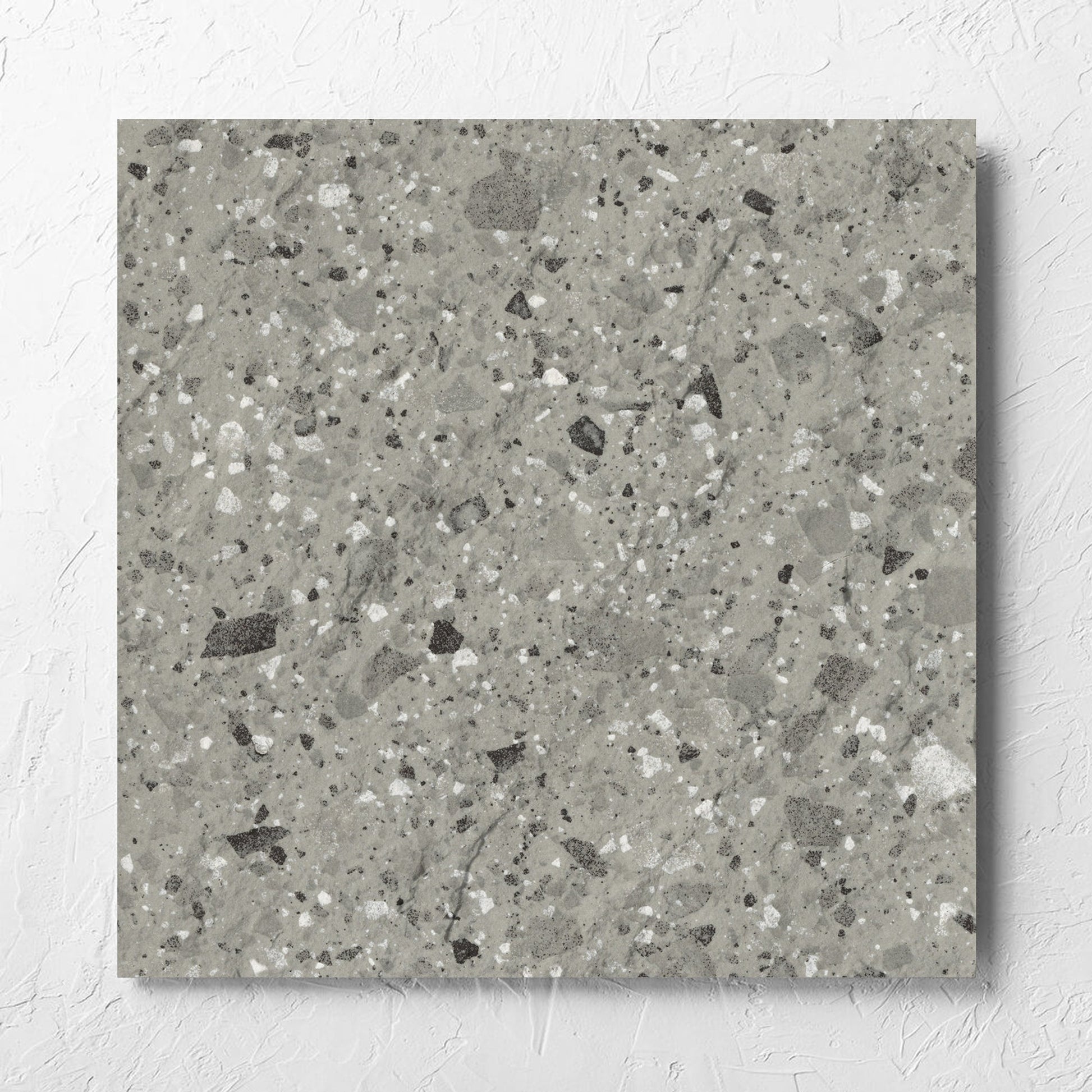 Venice Grey 600x600mm Matt Terrazzo External Tile laid flat on a white rendered wall, showing the grey matt surface