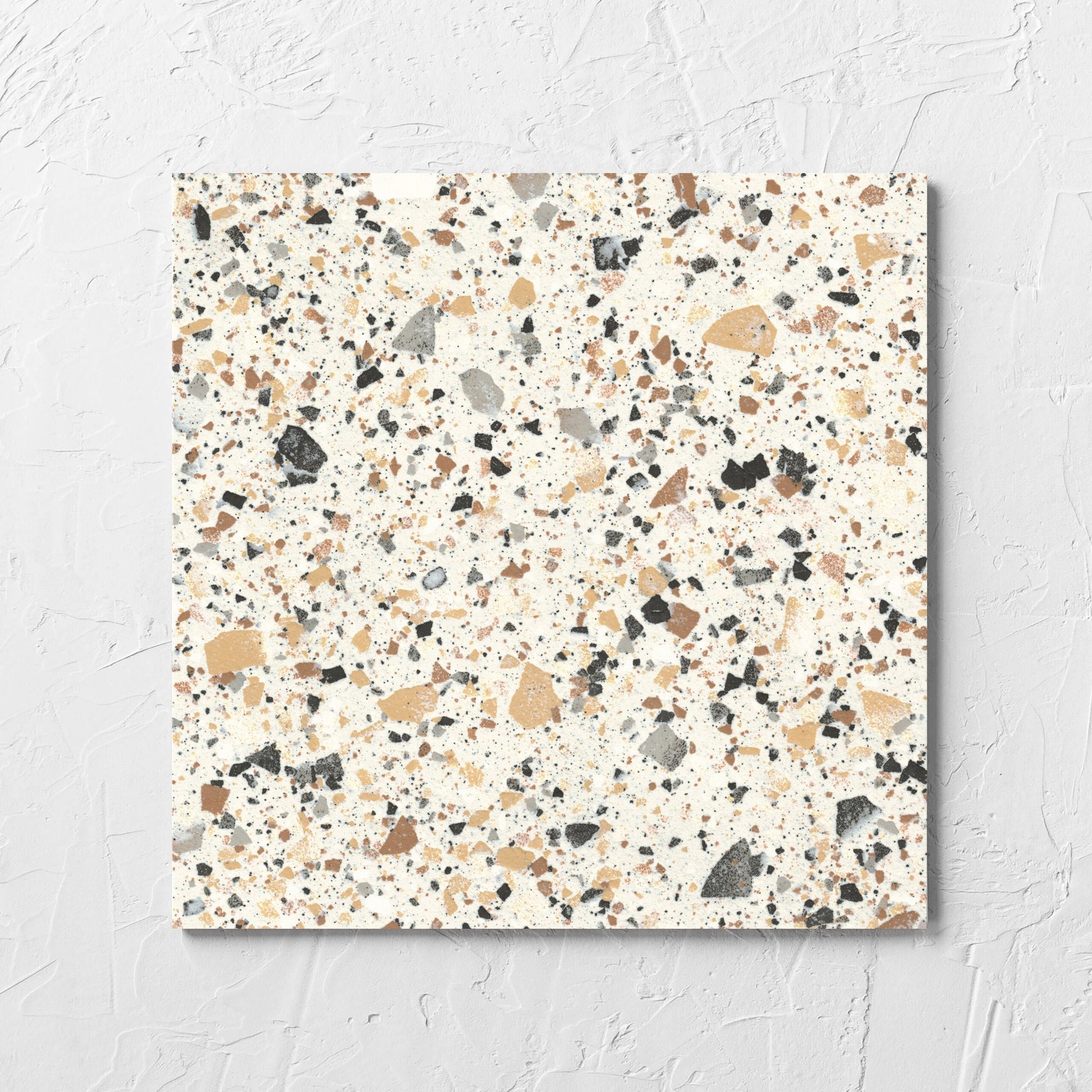 Venice Ivory 300x300mm Matt Terrazzo Tile laid flat on a white rendered wall, showing the ivory matt surface