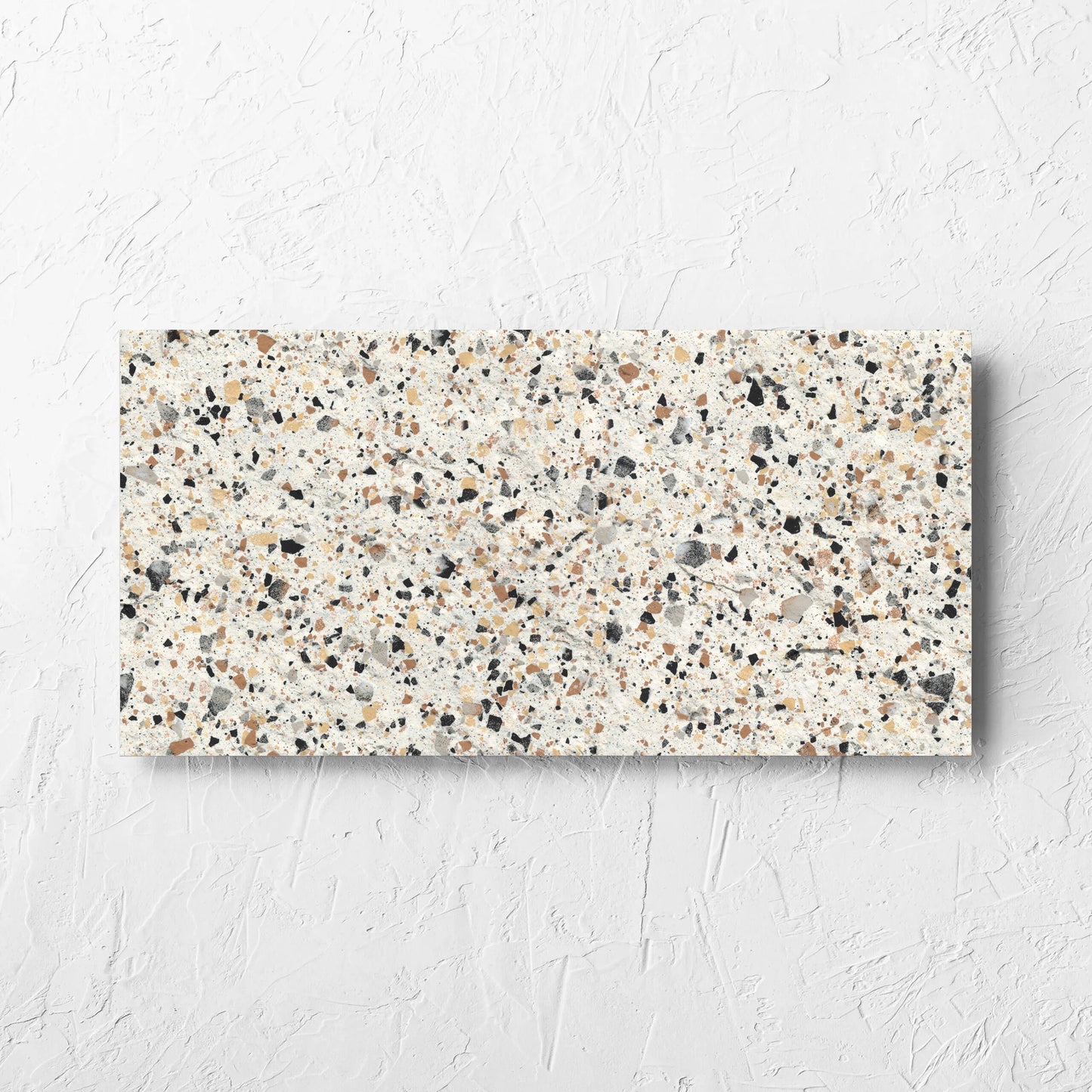 Venice Ivory 300x600mm Matt Terrazzo External Tile laid flat on a white rendered wall, showing the ivory matt surface