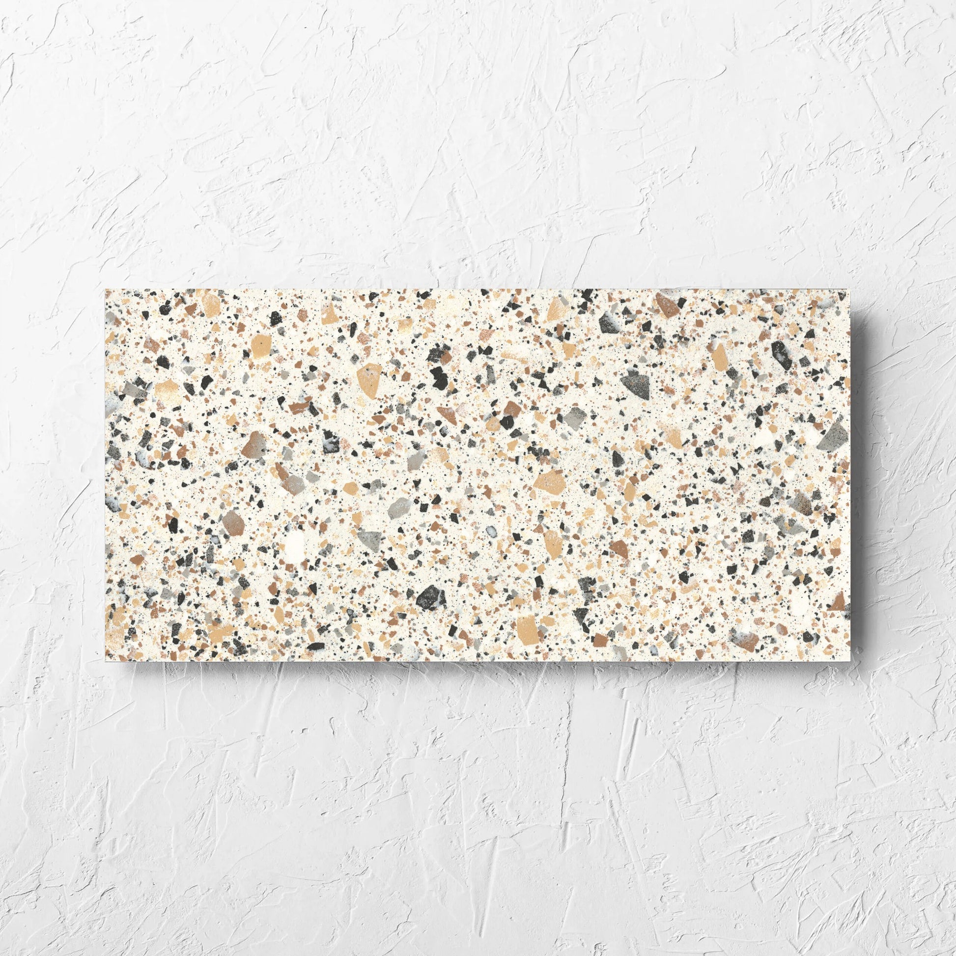 Venice Ivory 300x600mm Matt Terrazzo Tile tile laid flat on a white rendered wall, showing the tile surface