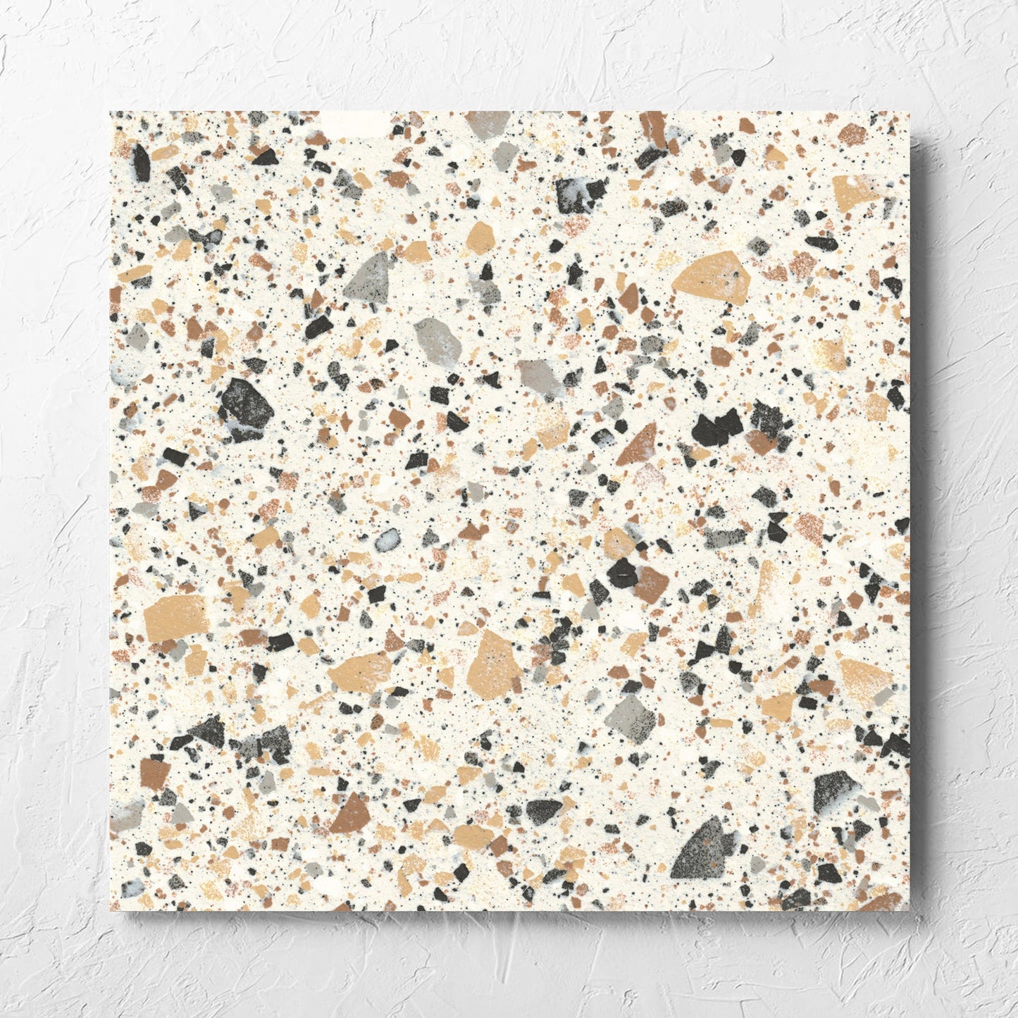 Venice Ivory 600x600mm Matt Terrazzo Tile laid flat on a white rendered wall, showing the ivory matt surface