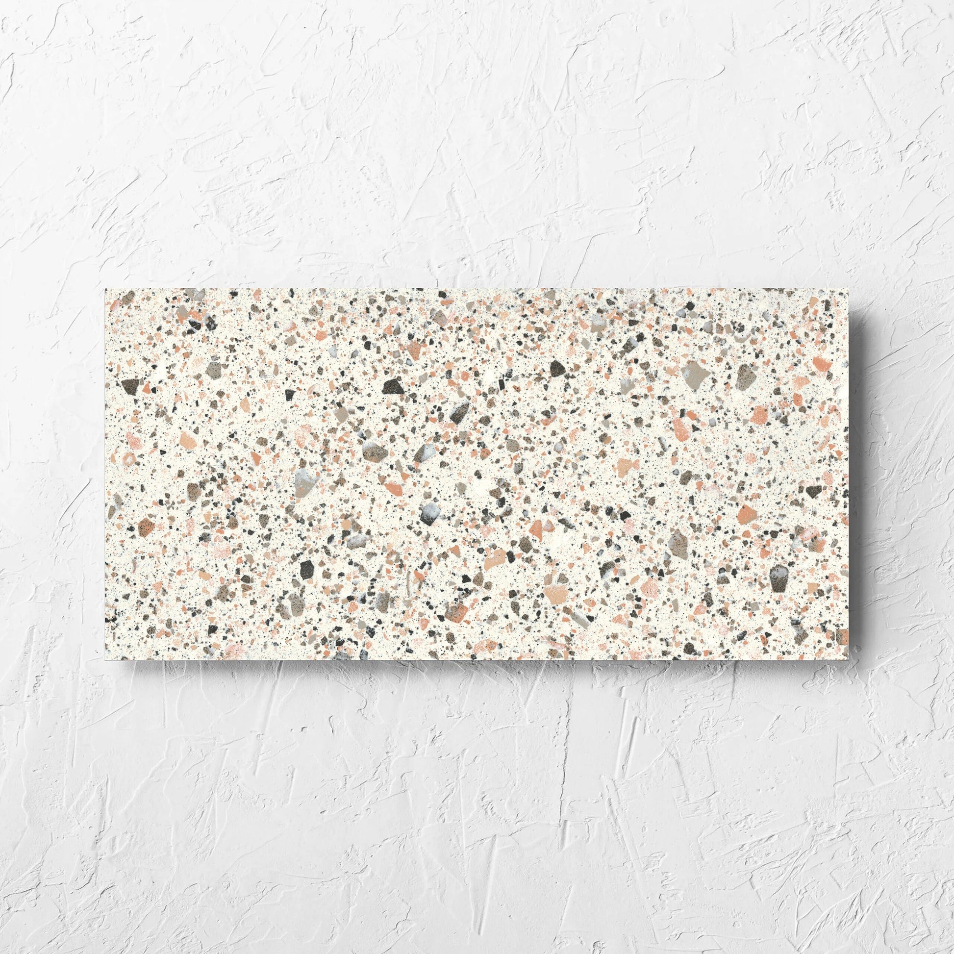 Venice Pink 300x600mm Matt Terrazzo Tile laid flat on a white rendered wall, showing the pink matt surface