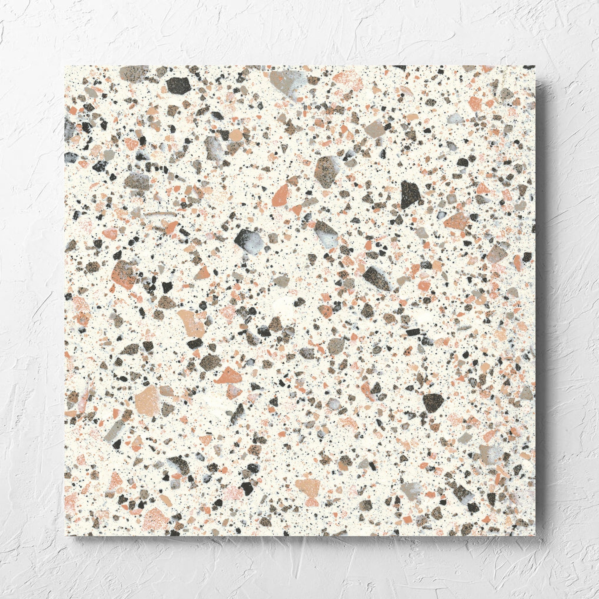 Venice Pink 600x600mm Matt Terrazzo Tile laid flat on a white rendered wall, showing the pink matt surface