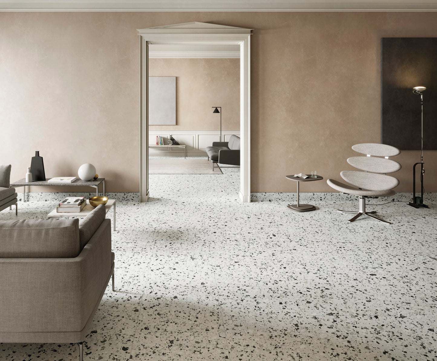 Venice Silver 300x300mm Matt Terrazzo Tile installed across a spacious living room floor with a modern lounge chair, sofa, and elegant doorway.