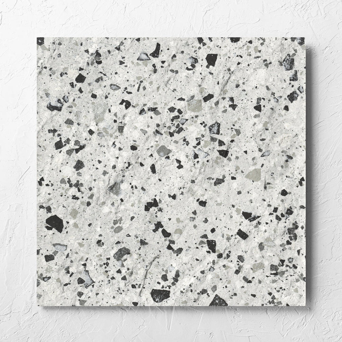 Venice Silver 600x600mm Matt Terrazzo External Tile laid flat on a white rendered wall, showing the silver matt surface