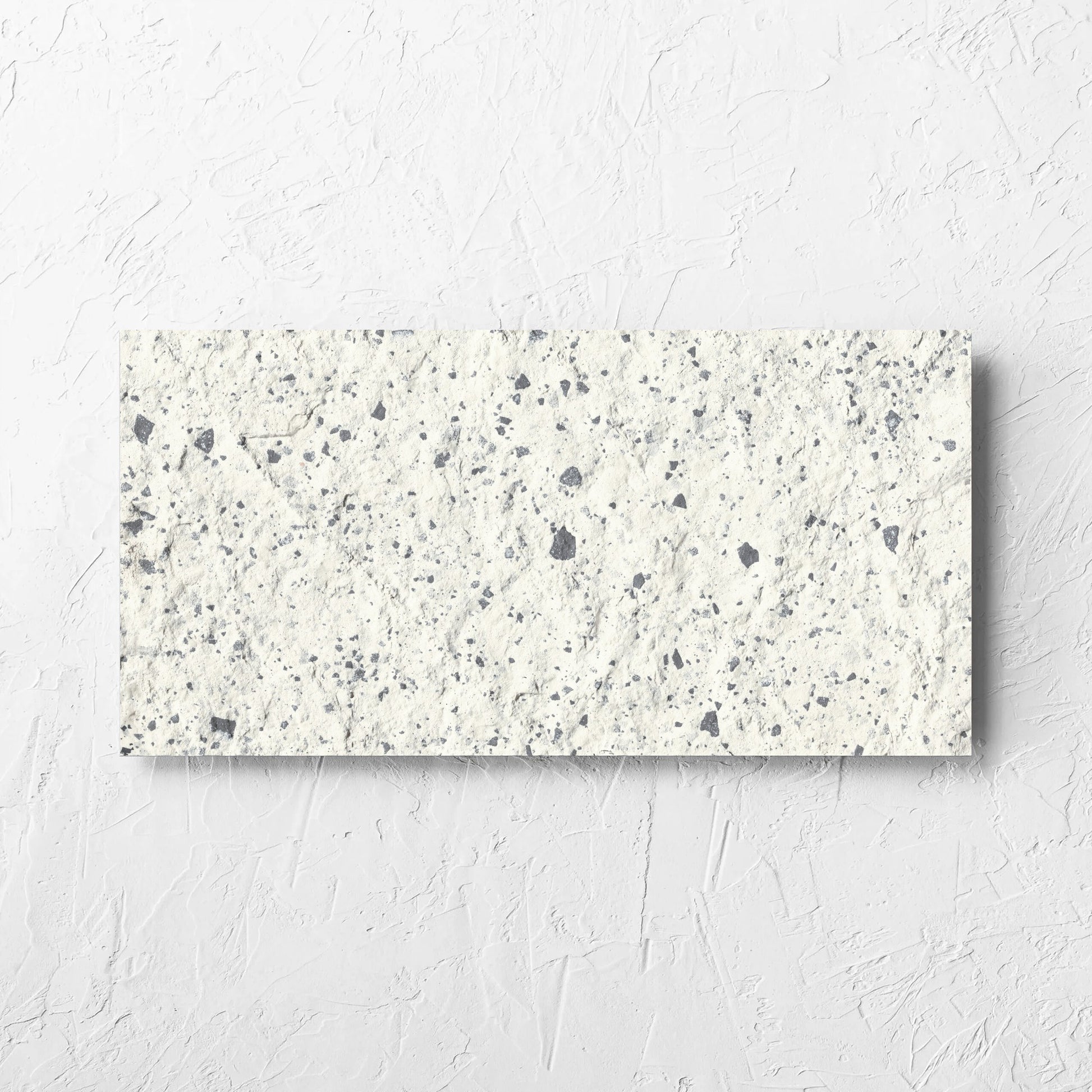 Venice White 300x600mm Matt Terrazzo External Tile laid flat on a white rendered wall, showing the white matt surface