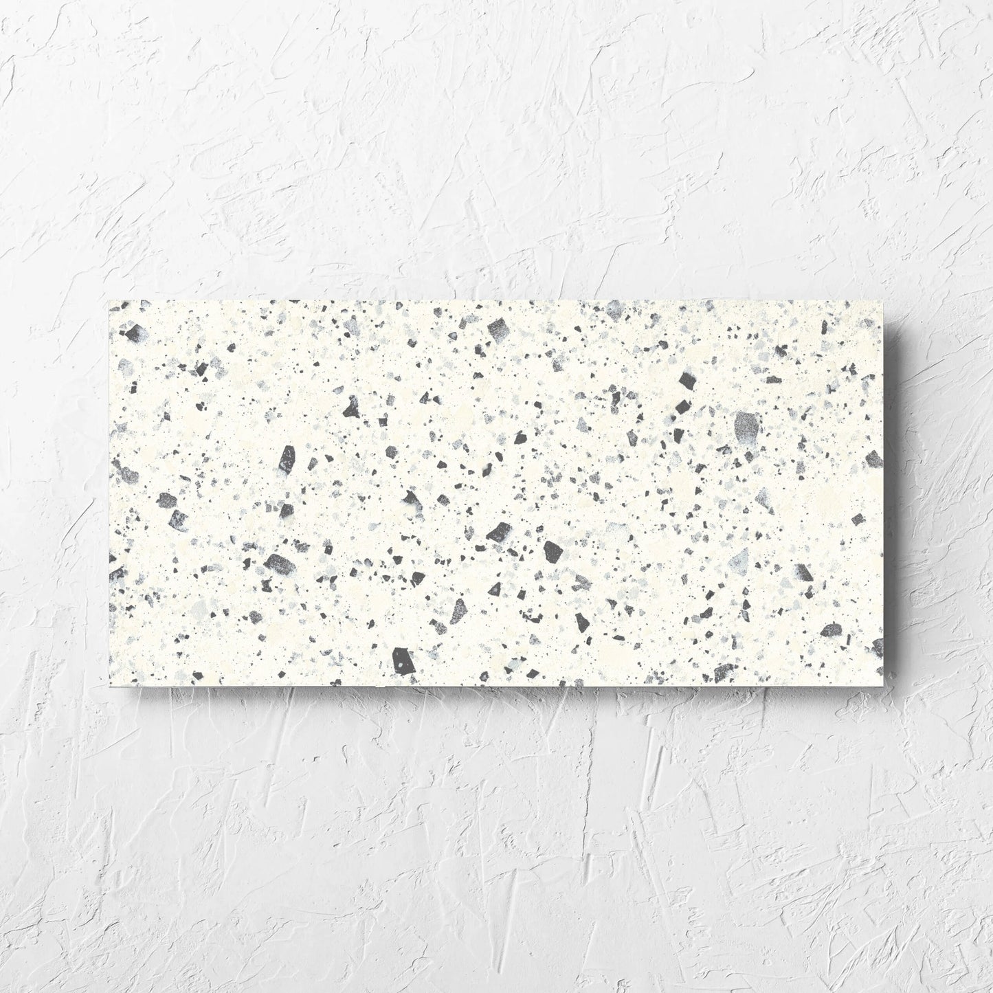Venice White 300x600mm Matt Terrazzo Tile laid flat on a white rendered wall, showing the white matt surface