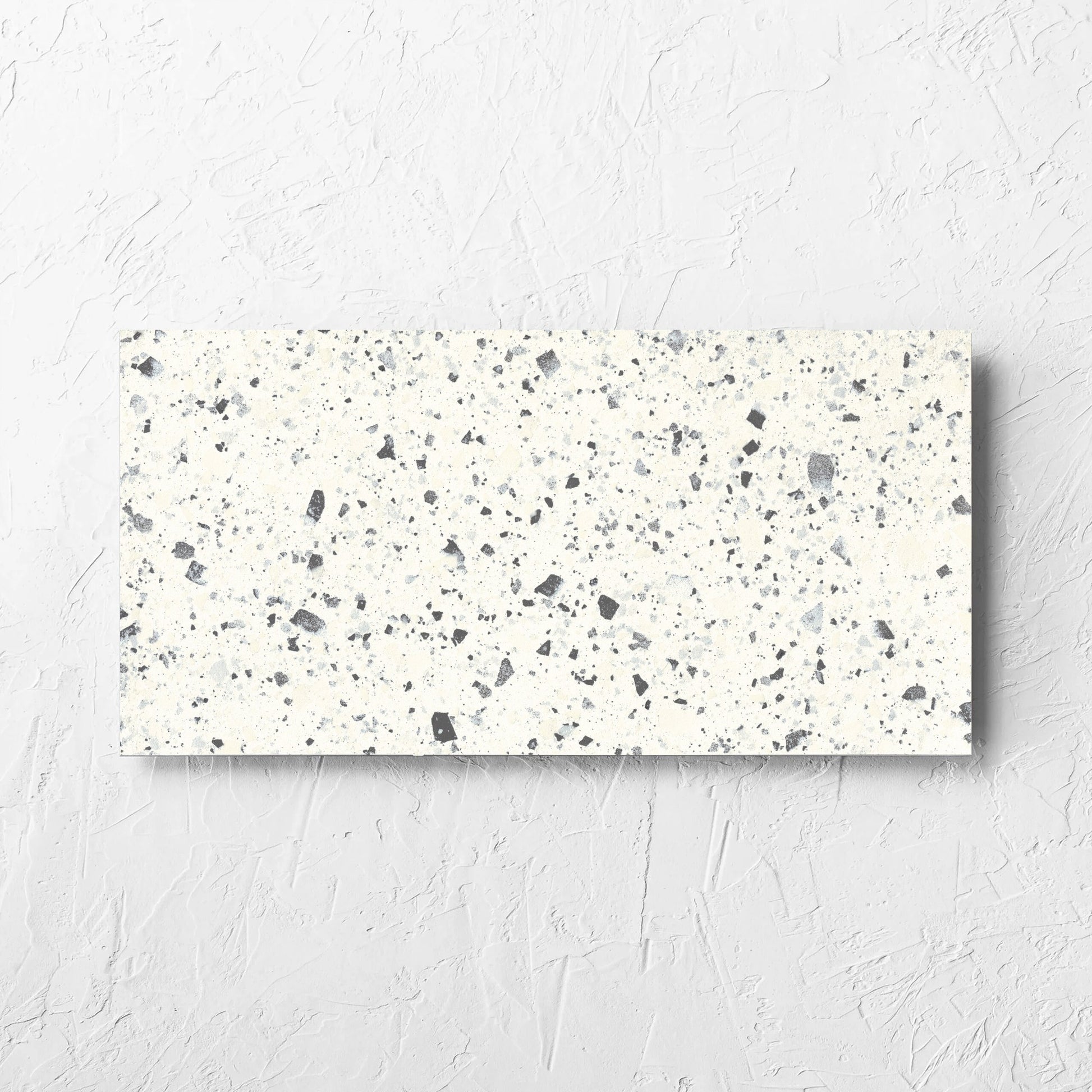 Venice White 300x600mm Matt Terrazzo Tile laid flat on a white rendered wall, showing the white matt surface