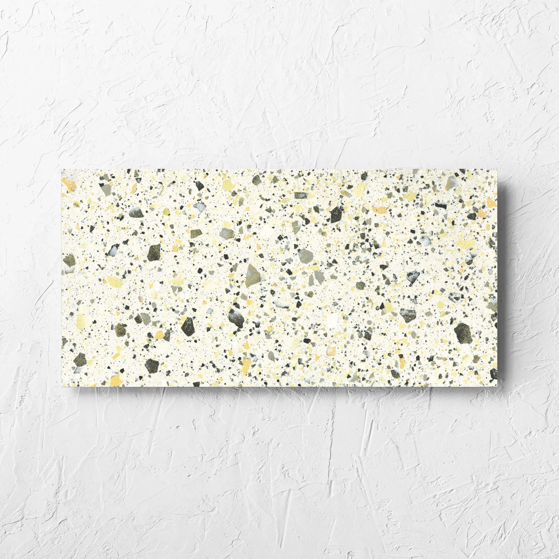 Venice Yellow 300x600mm Matt Terrazzo Tile laid flat on a white rendered wall, showing the yellow matt surface