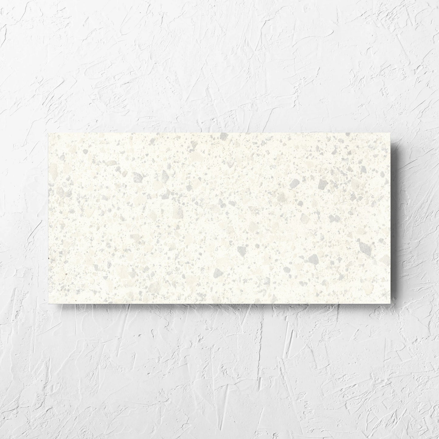 Venice Zinc 300x600mm Matt Terrazzo Tile laid flat on a white rendered wall, showing the zinc matt surface