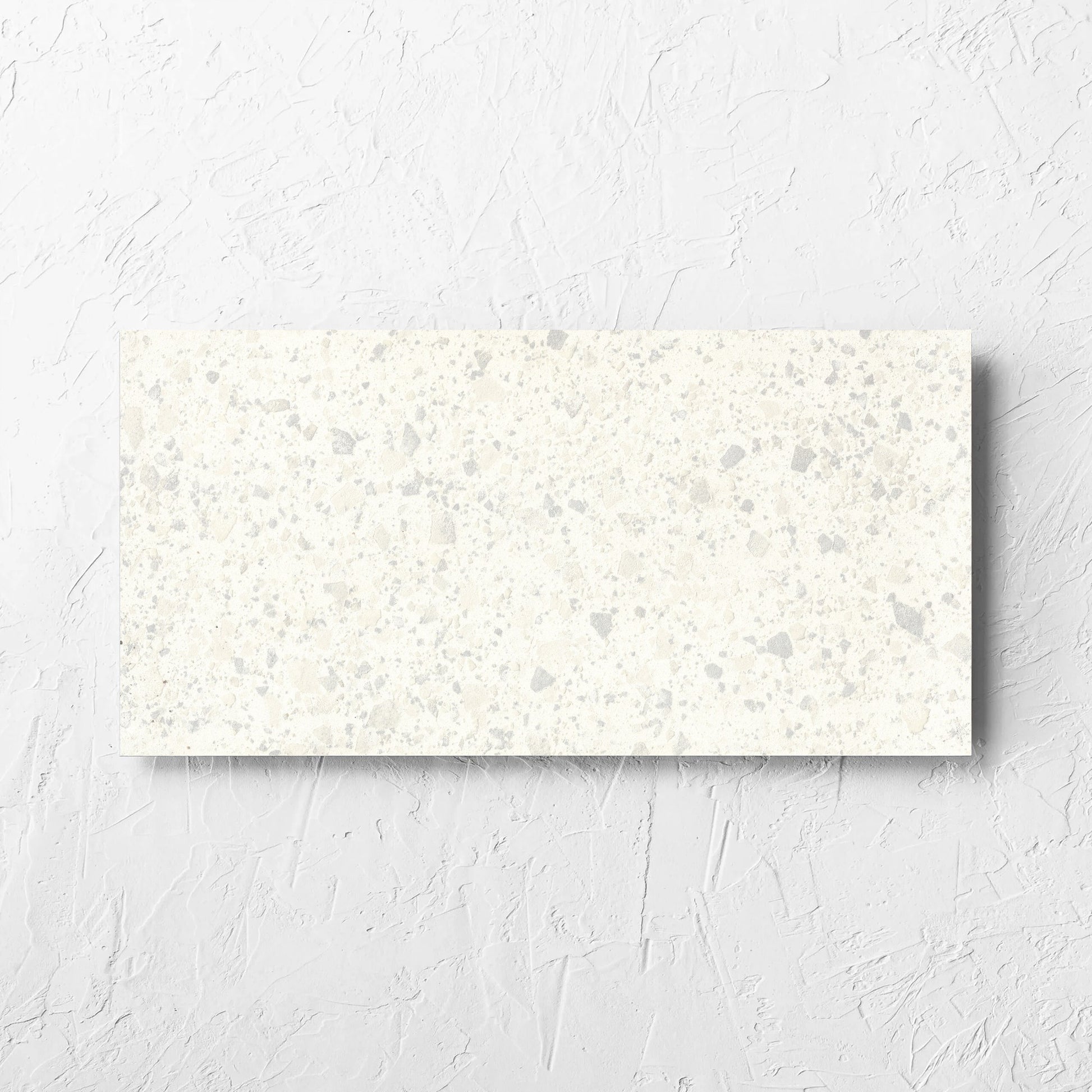 Venice Zinc 300x600mm Matt Terrazzo Tile laid flat on a white rendered wall, showing the zinc matt surface