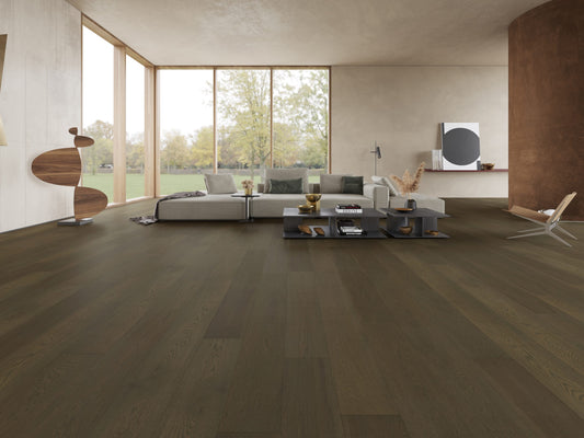 Vintage Grey Classique Oak Flooring 14/2mm installed in a spacious modern living room with a modular grey sofa, floor-to-ceiling windows, and dark wood coffee tables.