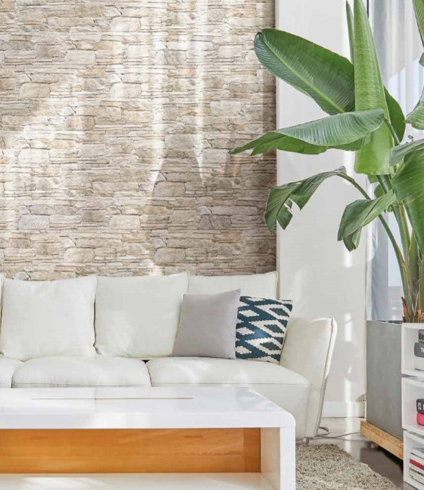Vulcani Avorio 160x400mm natural stone-look tiles installed as a feature wall behind a white sofa and large tropical indoor plant in a bright living room.