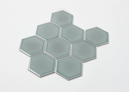 Pack shot of Water Green Gloss Porcelain Glazed Hexagon 95x110mm tiles arranged in a honeycomb cluster, showing smooth glossy finish and soft sage-green colour.