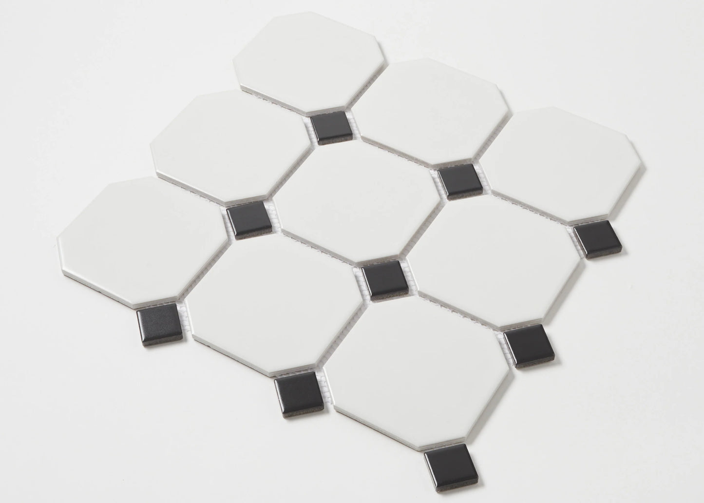 Pack shot of White and Black Matte Porcelain Glazed Octagon Large tiles showing matte white octagonal pieces with small black square dot inserts arranged in a classic pattern.
