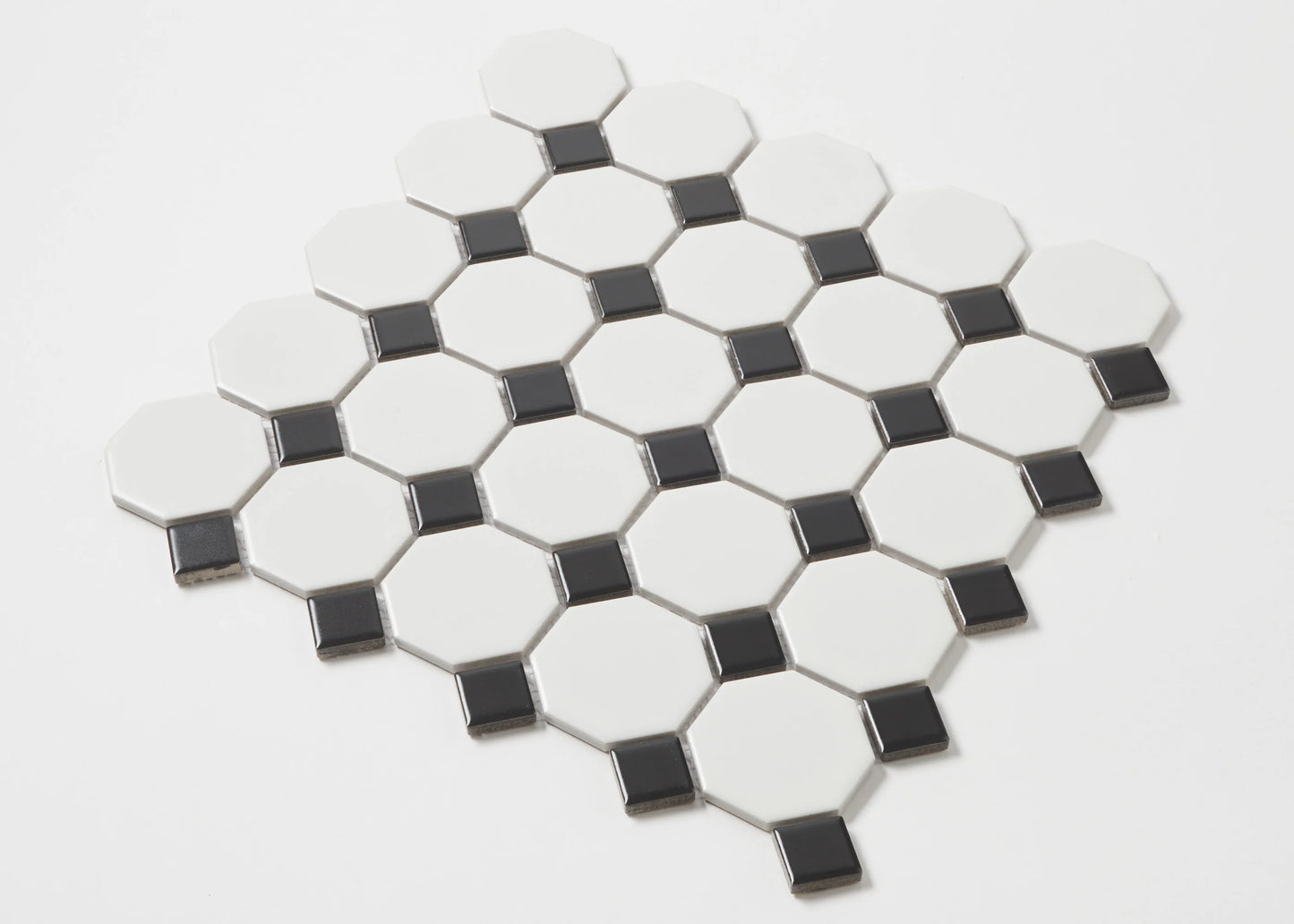 Pack shot of White and Black Matte Porcelain Glazed Octagon Small tiles showing glossy white octagon shapes with contrasting small black square dot inserts arranged in a diamond mosaic sheet.