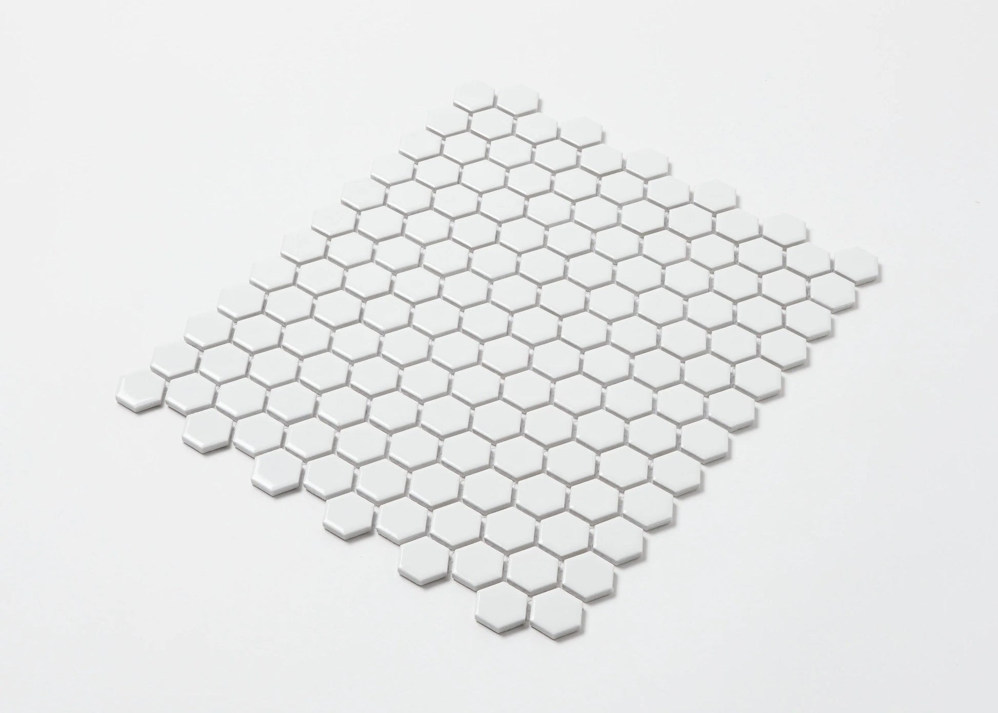 Pack shot of White Gloss Porcelain Glazed Hexagon 23mm mosaic tile sheet showing uniform white glossy hexagonal tiles arranged in a classic honeycomb pattern.