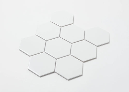 White Gloss Porcelain Glazed Hexagon 95x110mm tiles arranged in a loose cluster formation showing their glossy white finish and uniform hexagonal shape against a white background.