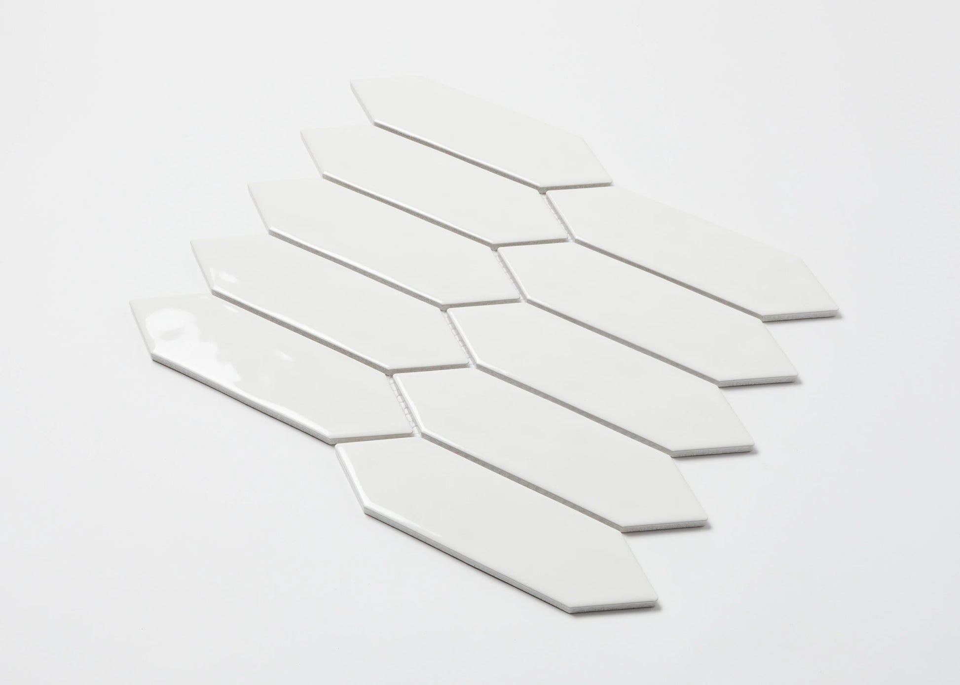 Pack shot of White Gloss Porcelain Glazed Ripple Surface Arrow 55x195mm tiles arranged in a fanned mosaic sheet showing elongated arrow-shaped white glossy ceramic pieces.