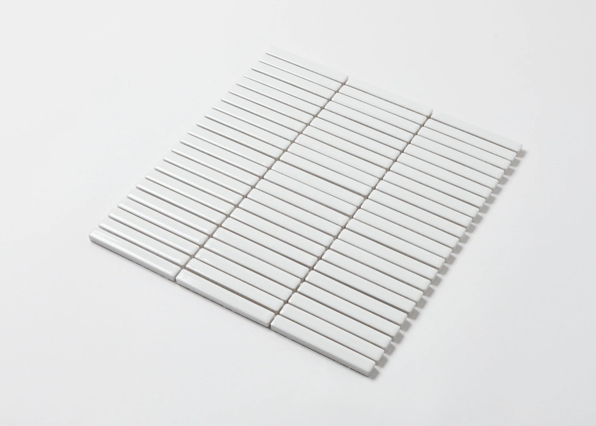 A single mesh-backed sheet of White Gloss Porcelain KitKat 12x92mm tiles arranged in parallel rows on a white background.