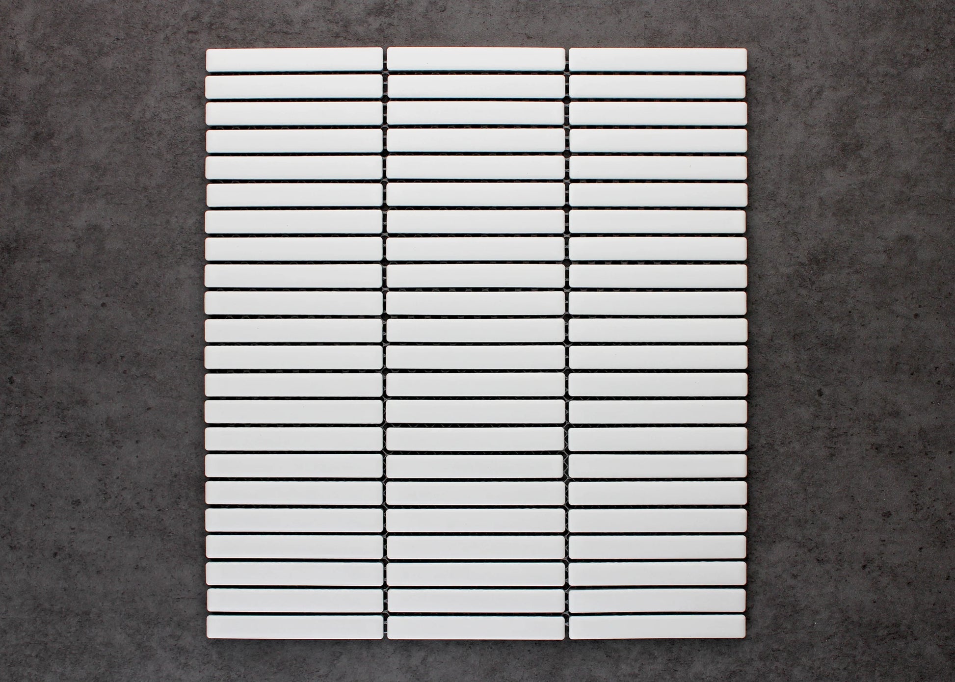 A flat-lay pack shot of White Matt Kitkat Straight Bone Pattern 12X92mm tiles arranged in a straight stacked grid of slim white rectangular bars with dark grout lines.