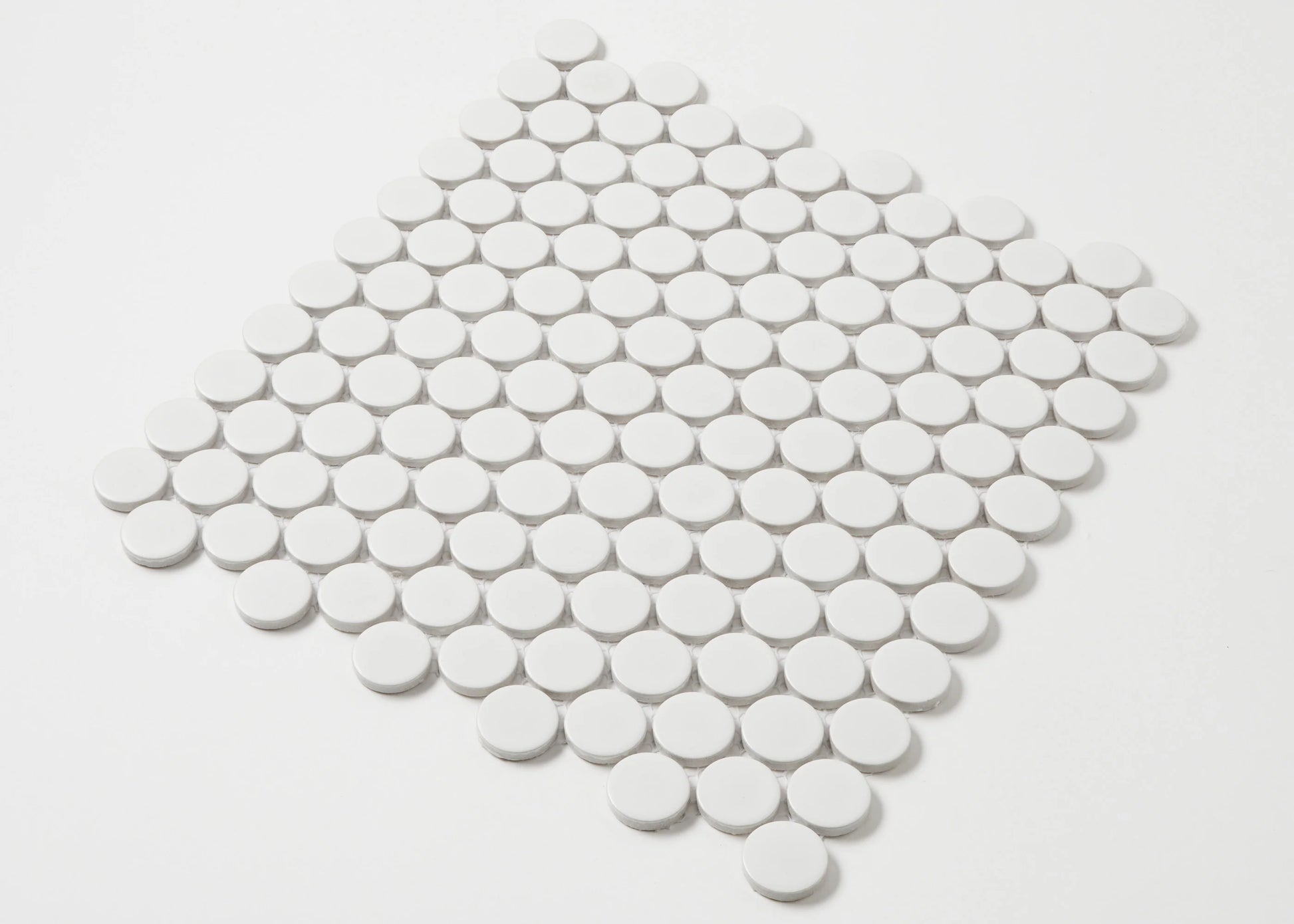 White Matte Glazed Porcelain Penny Round 28mm Diameter tiles arranged in a diamond-shaped mosaic sheet, showing matte white circular tiles with grey grout lines.