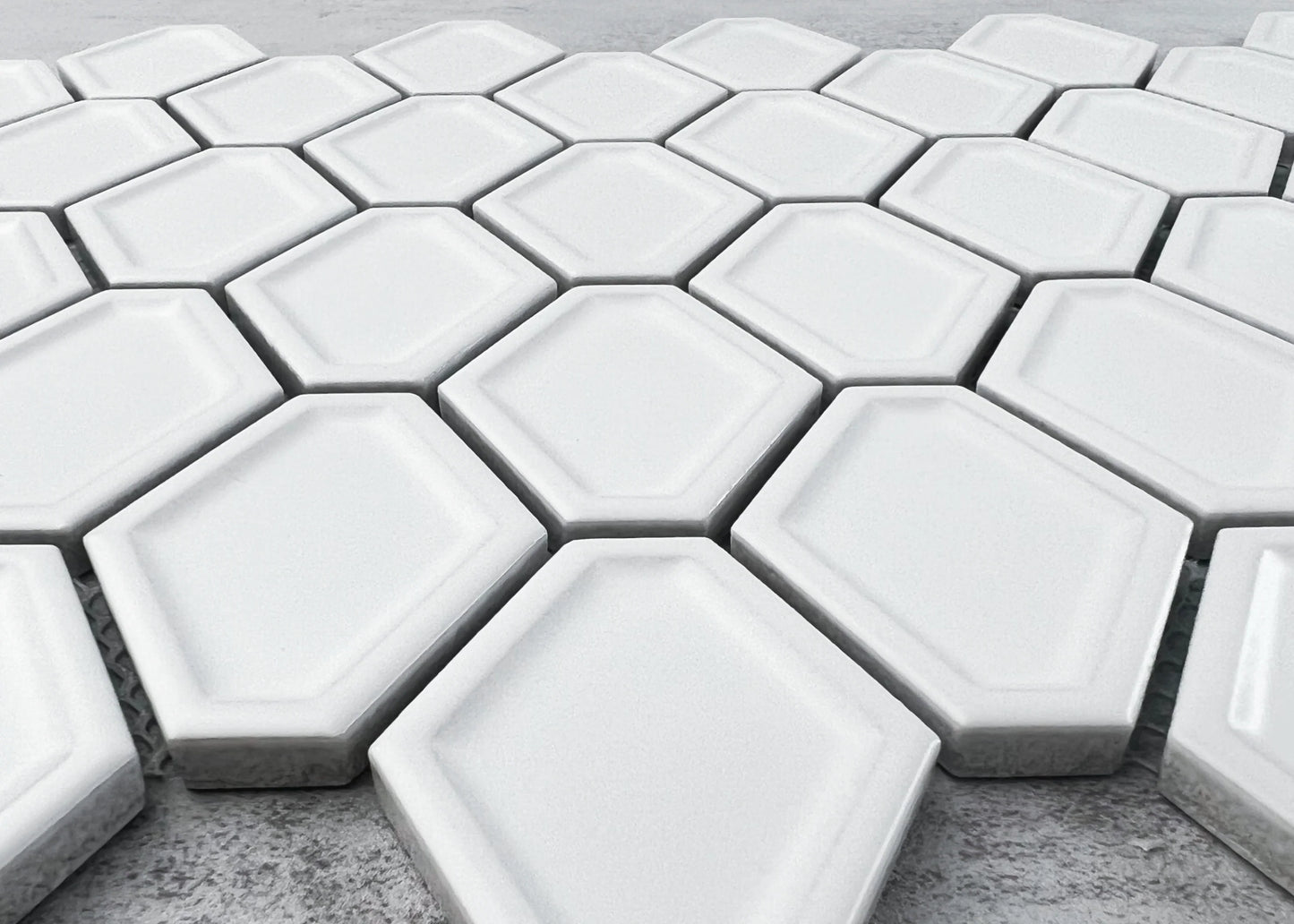 Close-up of White Matte Internal Porcelain Glazed Honeycombe Internal 46.5x60mm tiles arranged in a honeycomb pattern with bevelled edges and a smooth white matte glaze finish.