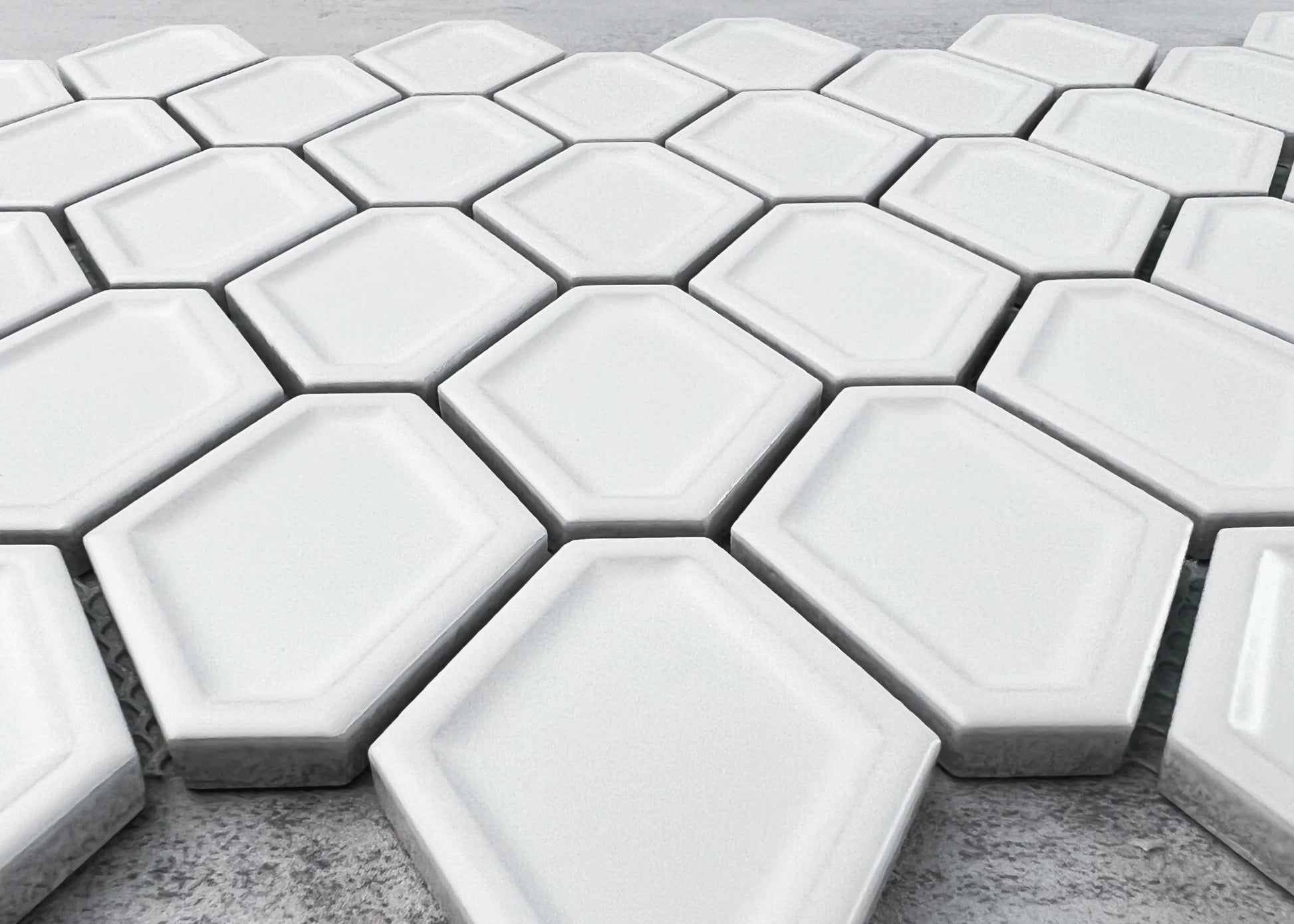 Close-up of White Matte Internal Porcelain Glazed Honeycombe Internal 46.5x60mm tiles arranged in a honeycomb pattern with bevelled edges and a smooth white matte glaze finish.