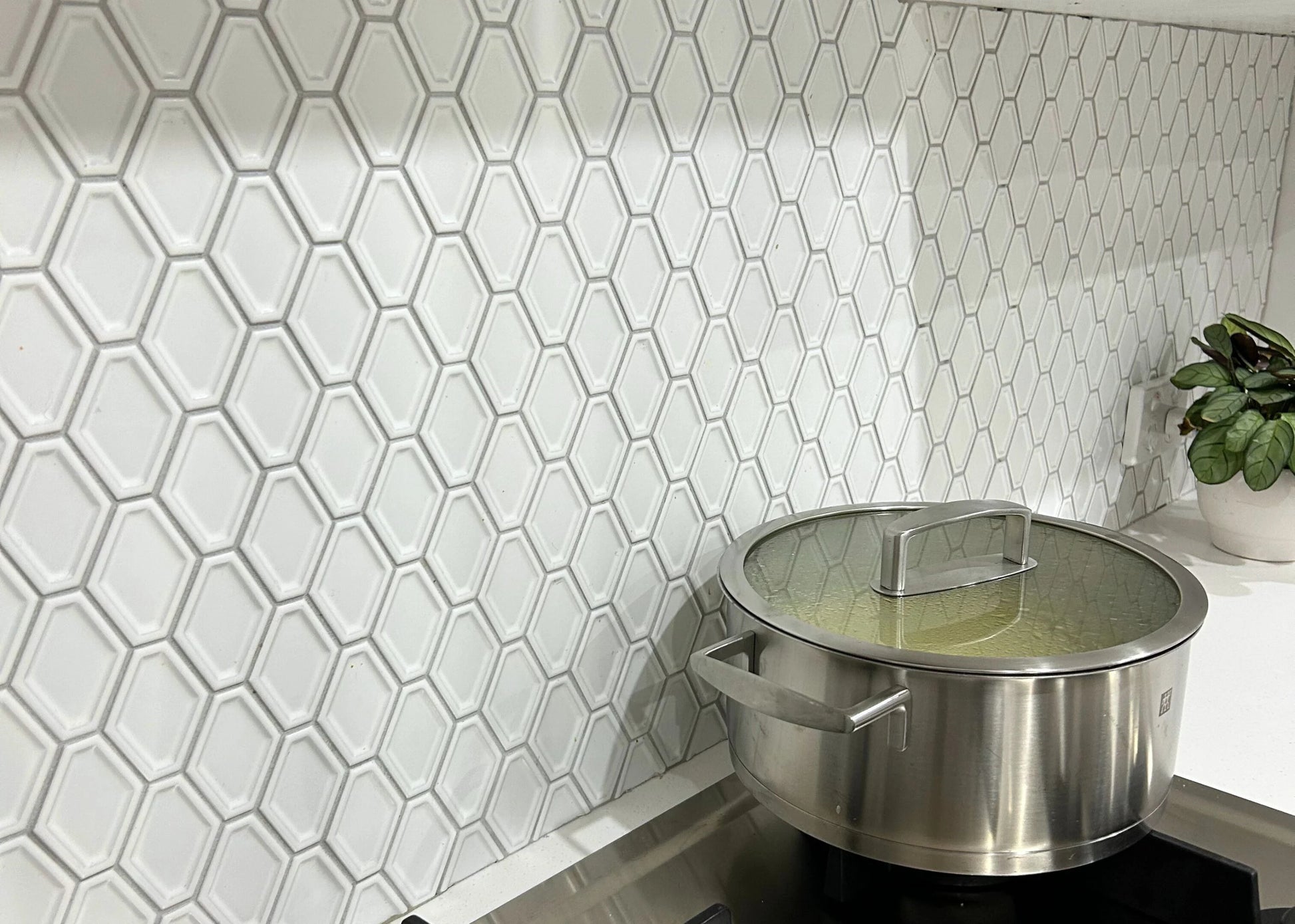 White Matte Internal Porcelain Glazed Honeycombe Internal 46.5x60mm installed as a kitchen splashback behind a stainless steel pot on an induction cooktop.