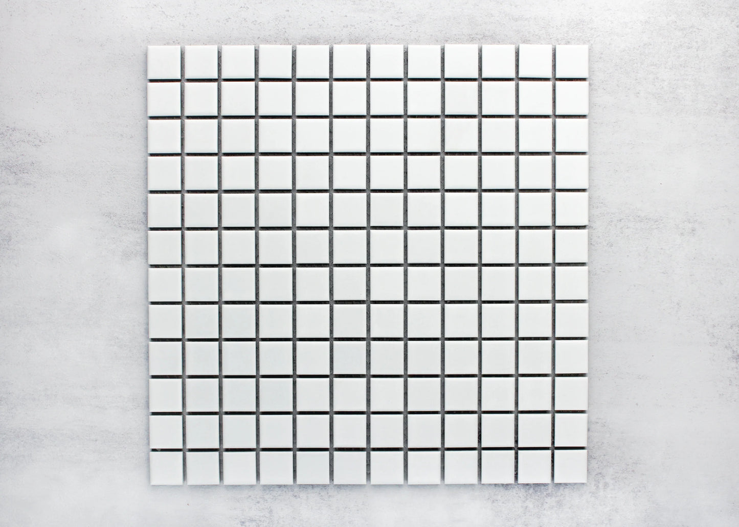 Pack shot of White Matte Porcelain Glazed 23x23mm Square tiles arranged in a uniform grid with dark grout lines on a light grey background.