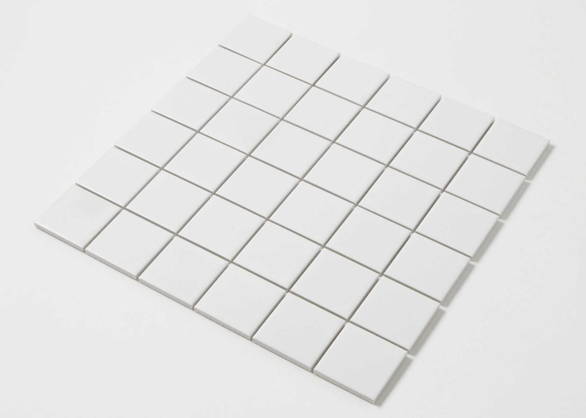 Pack shot of White Matte Porcelain Glazed 48x48mm Square tiles arranged in a 6x6 grid sheet showing a smooth matte white finish and uniform square format.