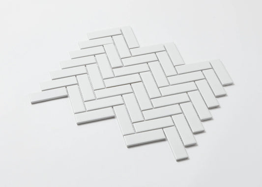 Pack shot of White Matte Porcelain Glazed Herringbone Bond 23x73mm tiles arranged in a classic diagonal herringbone pattern with a clean white matte finish.