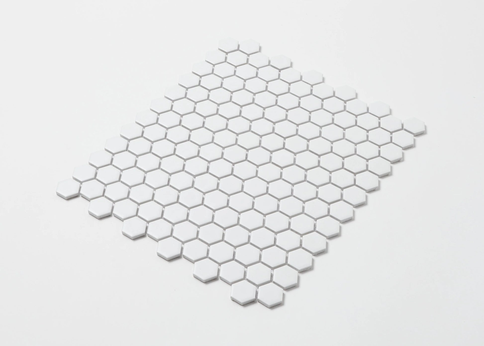 Pack shot of White Matte Porcelain Glazed Hexagon 23mm mosaic tile sheet arranged in a diamond layout showing uniform matte white finish and small hexagonal pattern.
