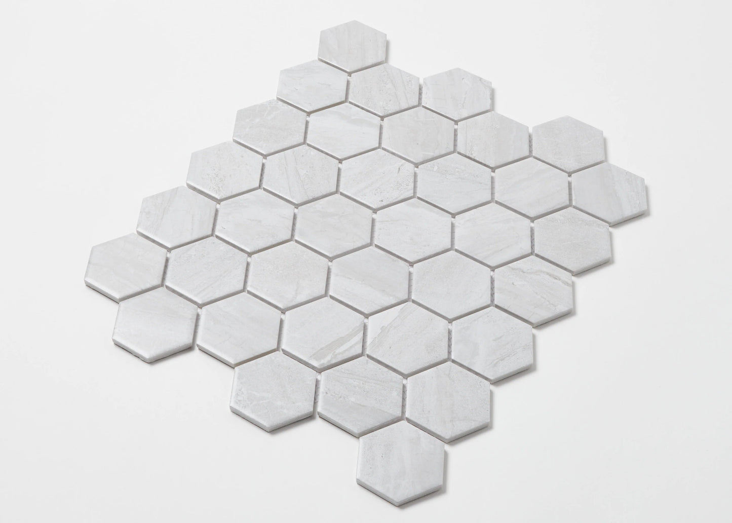 Pack shot of Wooden Grey Matte Porcelain Glazed Hexagon 51x59mm tiles arranged in a diamond mosaic sheet pattern showing subtle grey veining and matte finish.