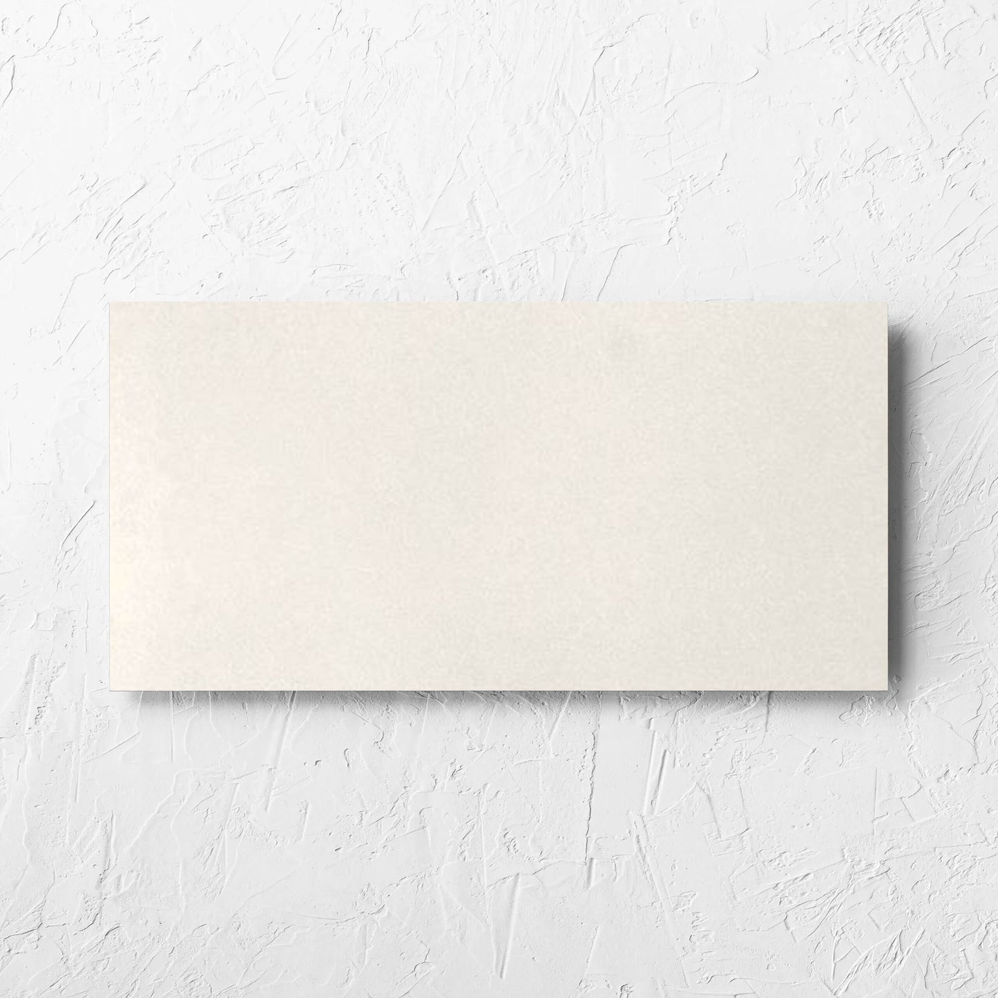 Yarra Bone Satin 300x600mm tile laid flat on a white rendered wall, showing the tile surface