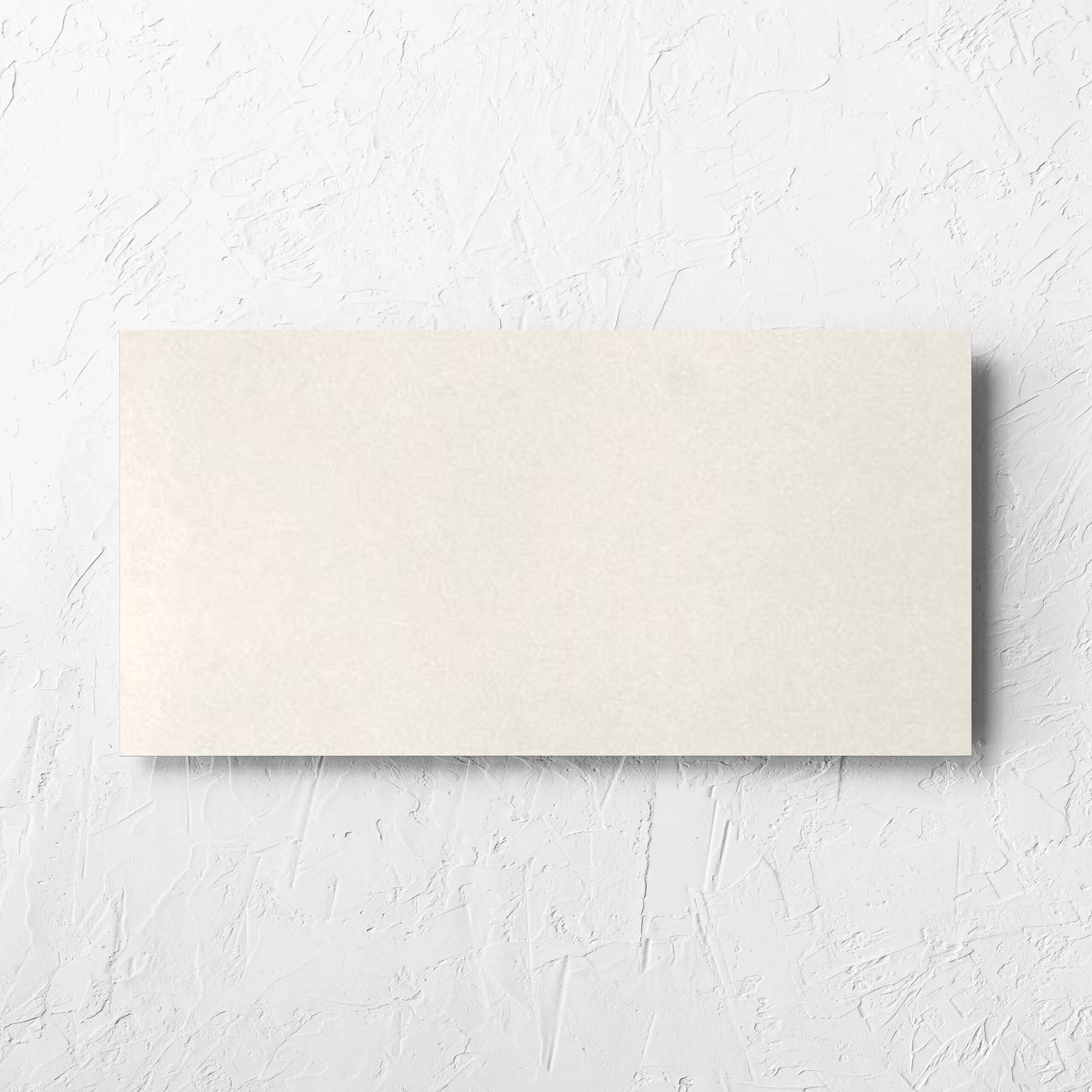Yarra Bone Satin 300x600mm tile laid flat on a white rendered wall, showing the tile surface