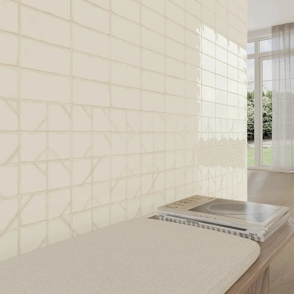 Yoko Daisy Gloss 62.5x125mm cream rectangular tiles installed as a full living room feature wall beside a cushioned bench with stacked magazines.